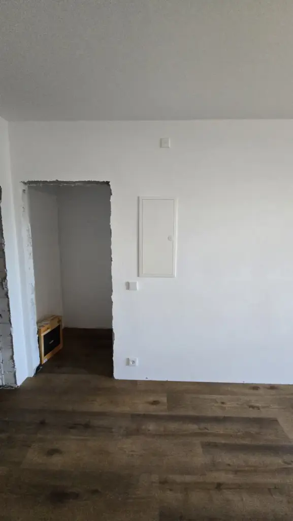 Heller, renovierter Raum mit Steckdosen und eingebauter Verteilertür in der Wand