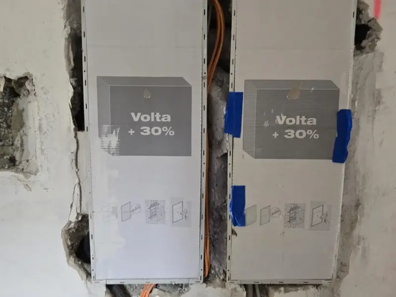 Zwei eingebaute Unterverteilungen in einer Wand mit zahlreichen zugeführten Leitungen
